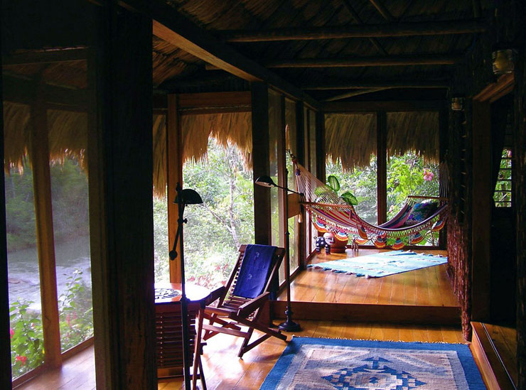 Screened porch with a view of gardens and the river